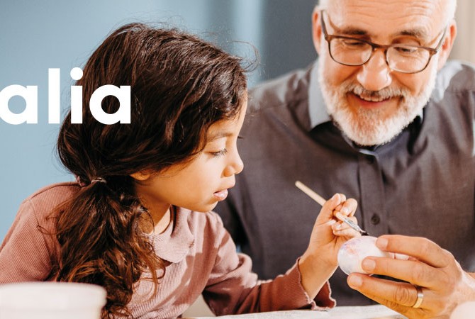 Kind malt mit Mann Ostereier an