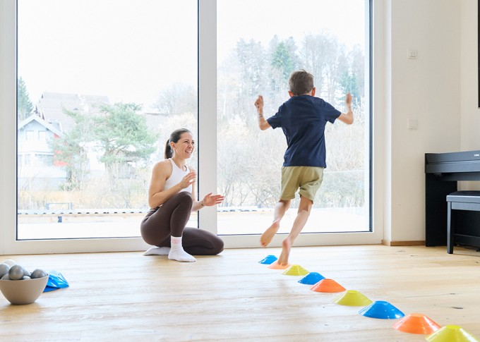 Frau macht Workout mit 2 Kindern und lächelt
