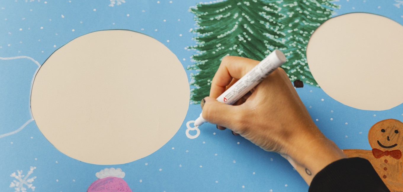 Eine Hand die die Zahl 8 auf ein blaues Plakat schreibt.