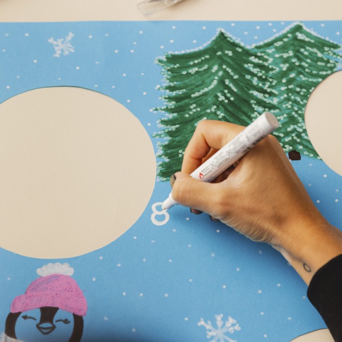 Eine Hand die die Zahl 8 auf ein blaues Plakat schreibt.