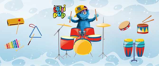 Das Maskottchen von Lollipop, Happy, sitzt am Schlagzeug und um ihn herum sieht man verschiedene Schlaginstrumente.
