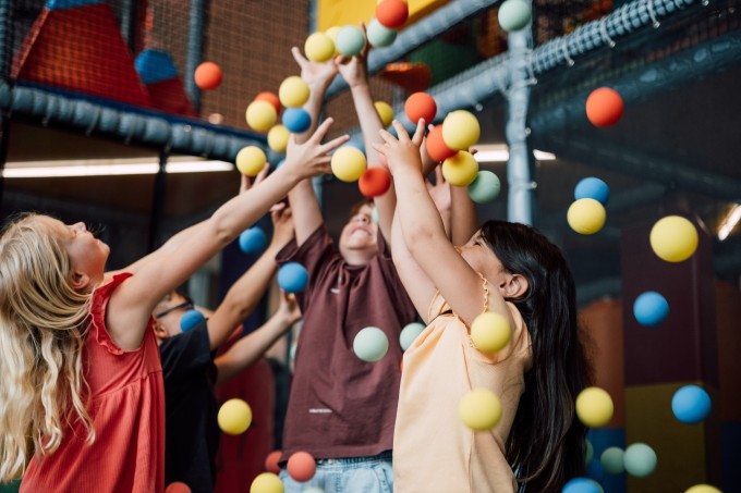 Kinder spielen mit kleinen Bällen, die herunterfallen