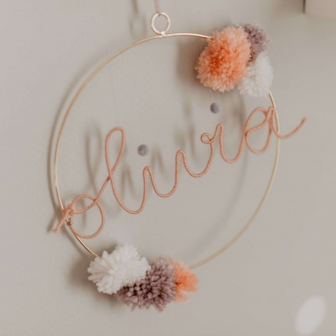 Ein Kreis, indem der Name Olivia steht. Am Rand des Kreises sind bunte Kugeln.